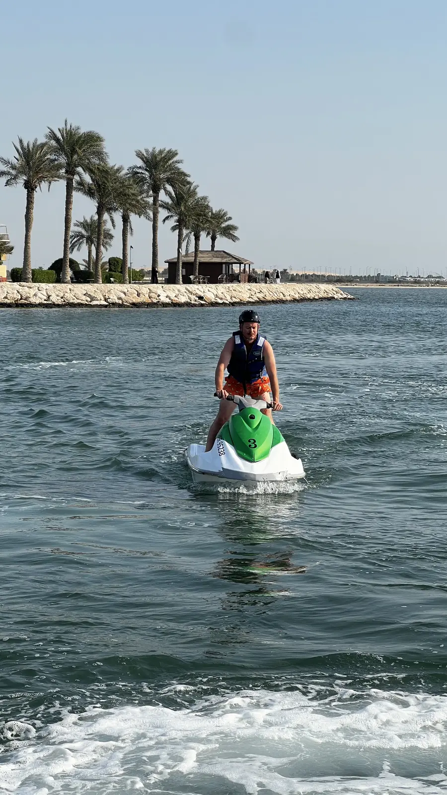 Jet ski rider cruising along the palm-lined coastline near Khobar