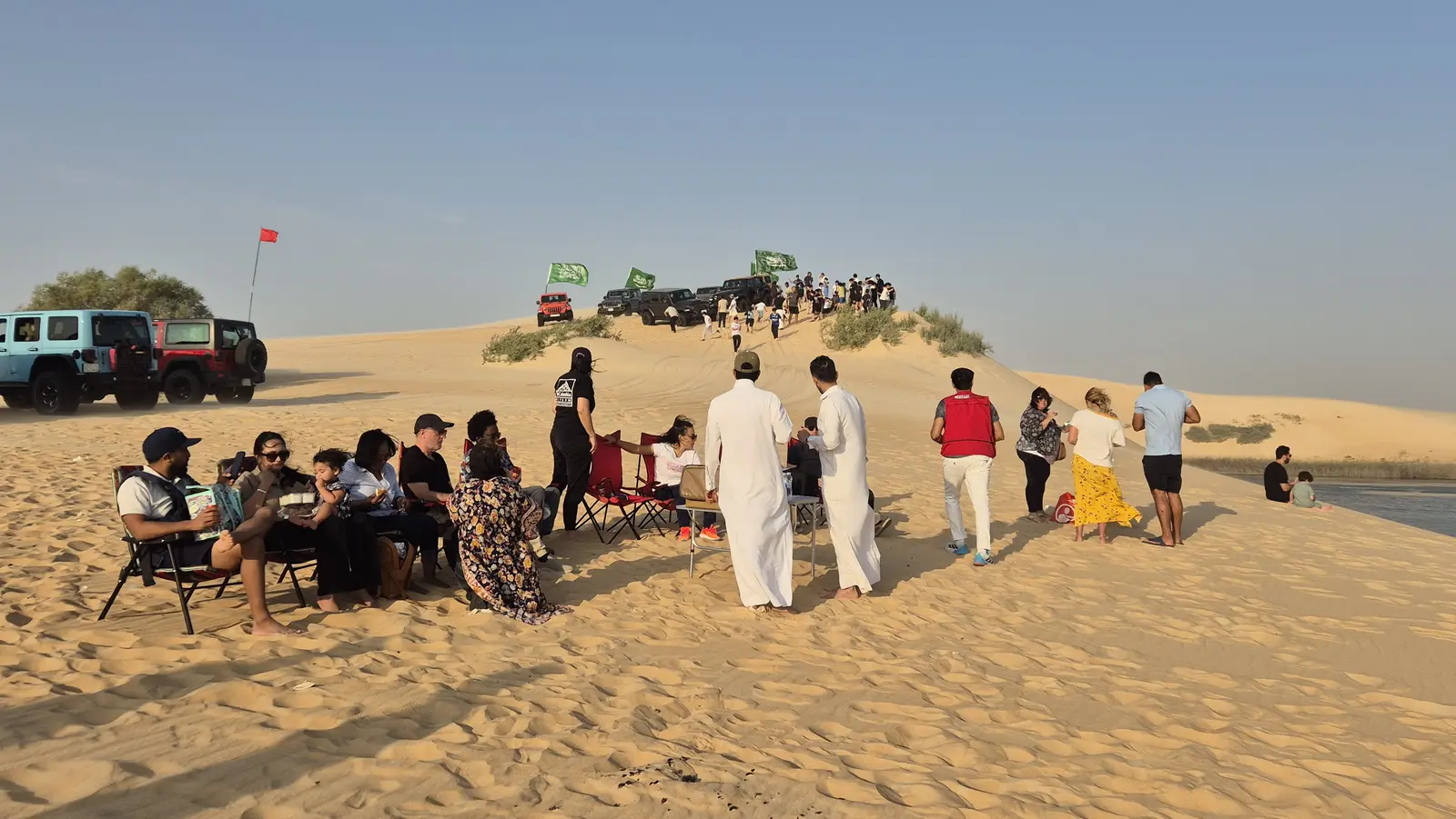 Group relaxing at the desert camp during golden hour near Al Asfar Lake