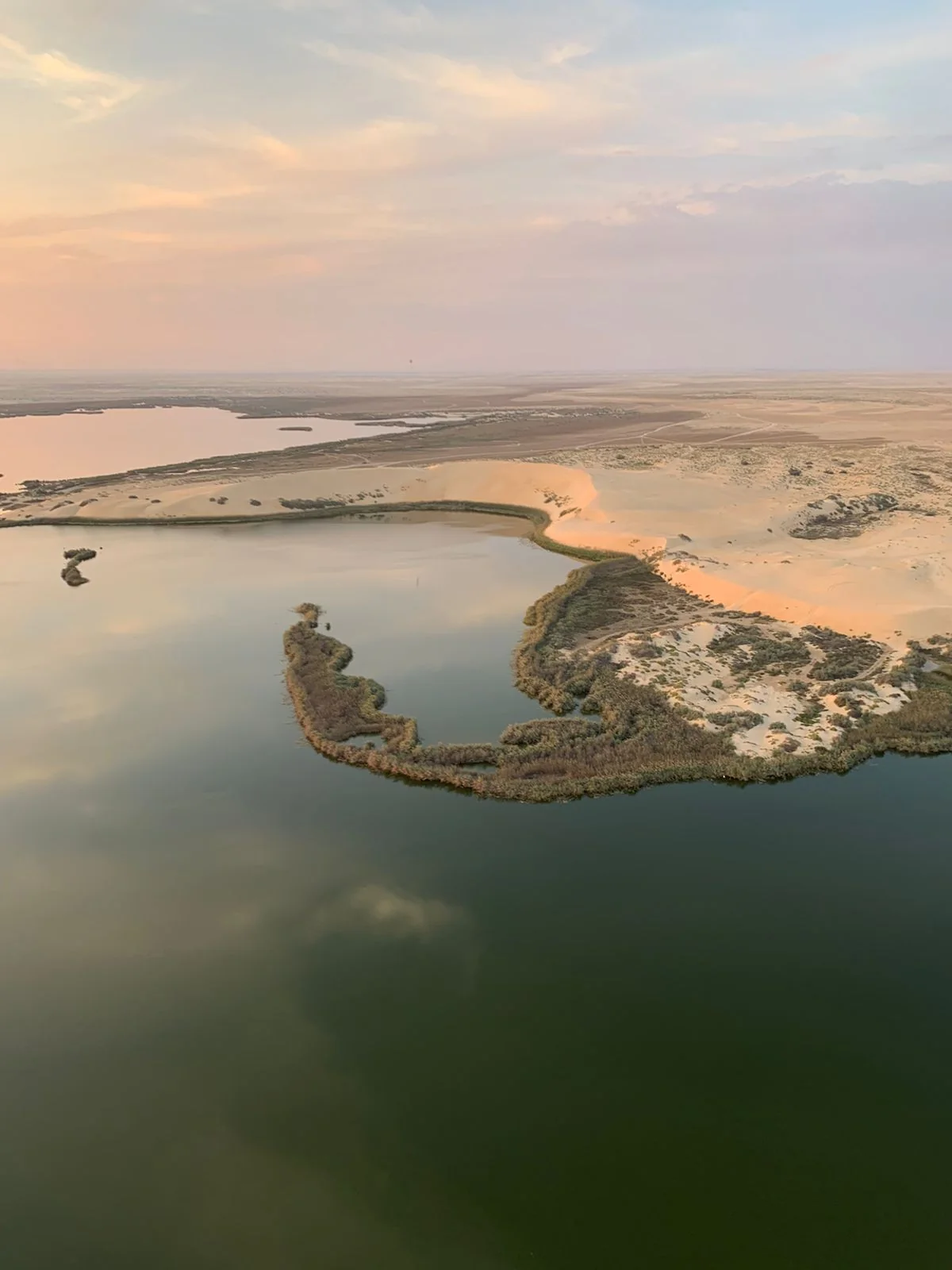 Scenic view of Al Asfar Lake surrounded by desert dunes