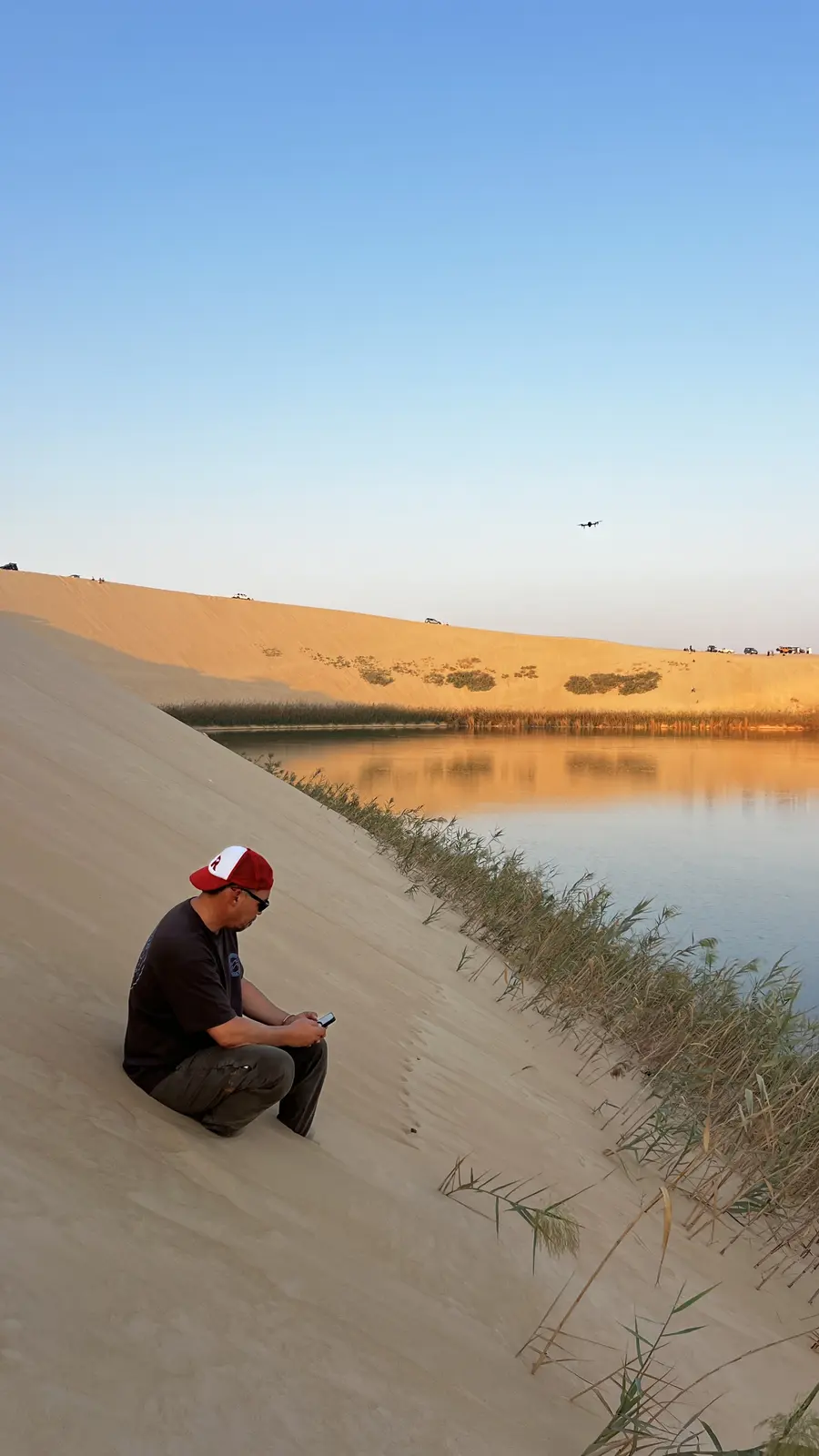 Visitor enjoying the peaceful golden-hour view over Al Asfar Lake