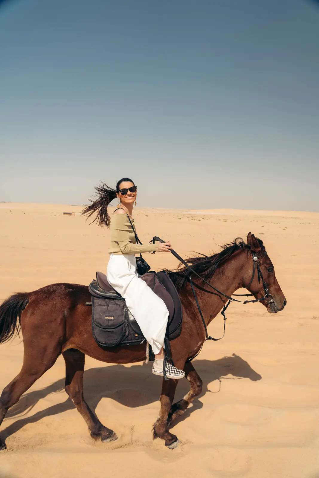 Rider trotting through the desert dunes near Dammam