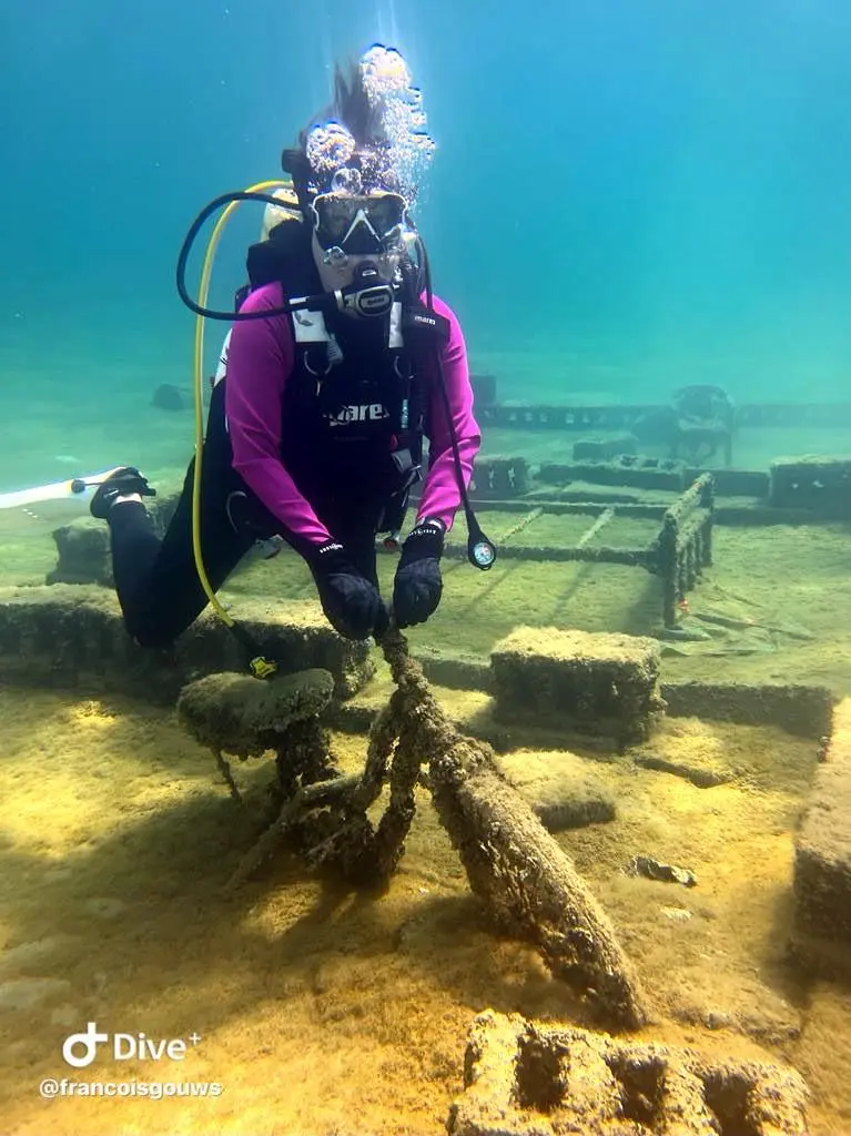 Certified instructor guiding a diver along the underwater museum wreck